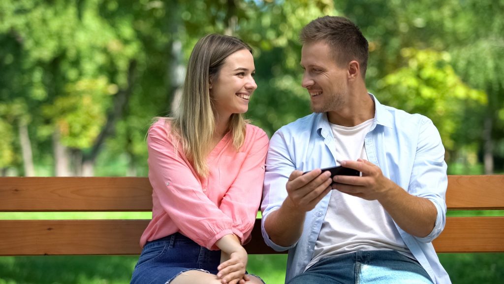 When should you kiss a girl on your date? Man and woman sitting next to each other, shoulder to shoulder, shoulders touching