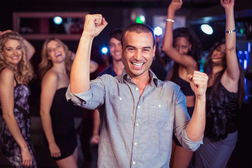 guy dancing in club surrounded by women after learning the anti-cockblock techniques to get rid of cockblockers