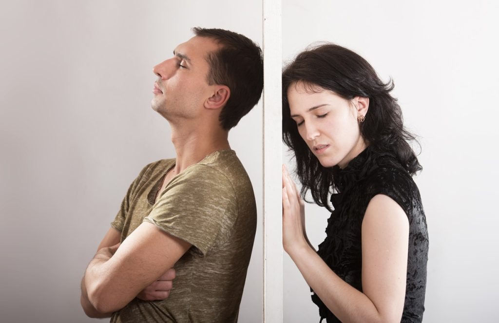 man and woman having a relationship crisis, not talking to each other, not communicating properly, separated by a wall, thinking of ending things