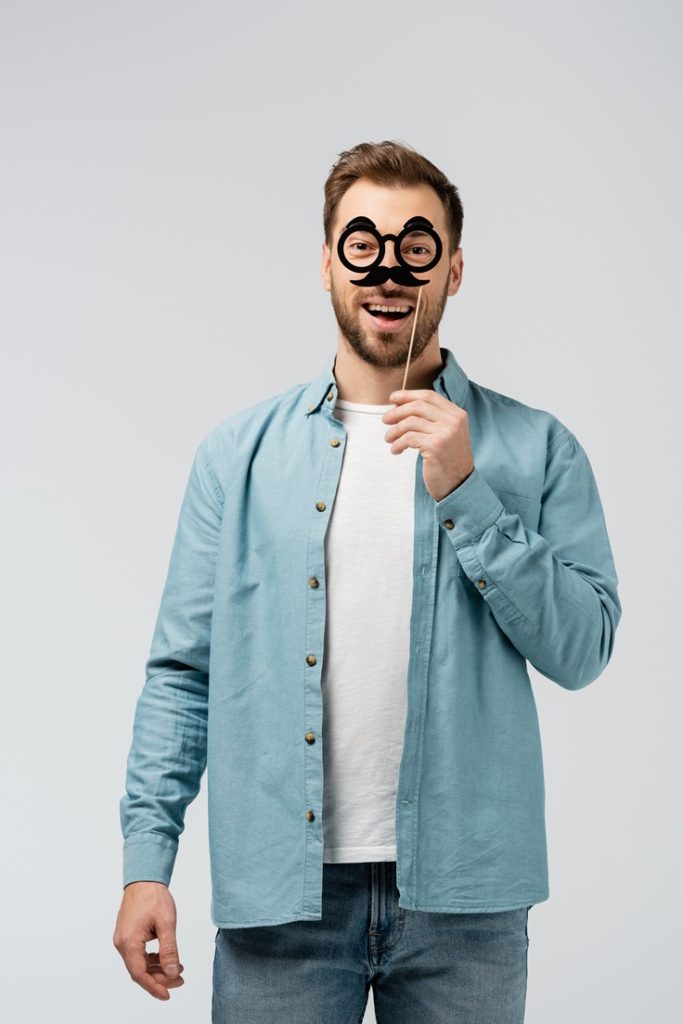 a man is amusing himself by wearing a fake mustache with goggles